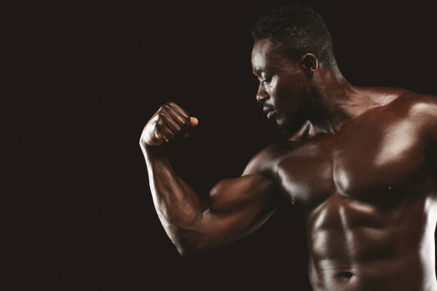 istock Handsome black bodybuilder demonstrating his arm strength 1172744172