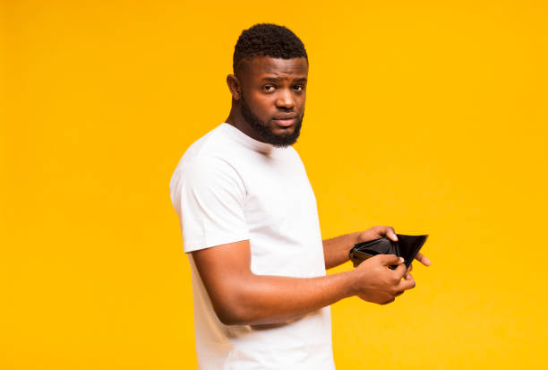 istock Sad african american man showing empty wallet 1172744365