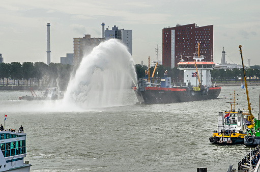 Rotterdam, The Netherlands, September 6, 2019: dredger Ecodelta creating an arch of water on the river Nieuwe Maas during the Wereldhavendagen (World Port Days) festival