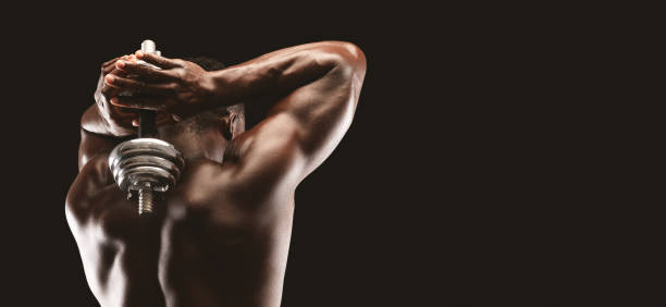 rear view of african bodybuilder pumping muscles - rear view human arm naked men imagens e fotografias de stock