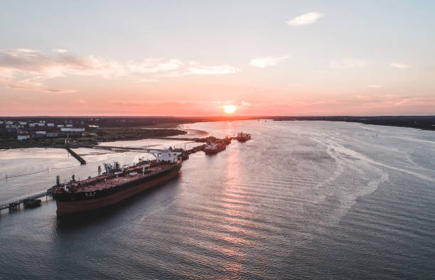 buques de carga en un pequeño muelle descargando mercancías - supertanker fotografías e imágenes de stock