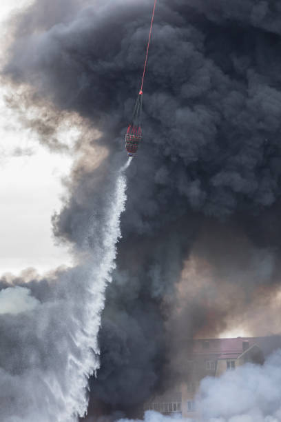 istock helicopter extinguishes a fire from a basket of water 1172749711