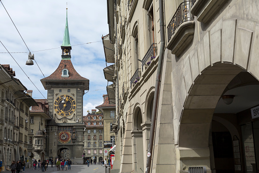 Bern, Switzerland - April 17, 2017: In the old town the Zytglogge is seen at the end of a street. This medieval tower is one of the most visited landmarks in the city. This is one of the countless wonderful places in Switzerland, which is a tourist attraction often visited by many tourists from all over the world.