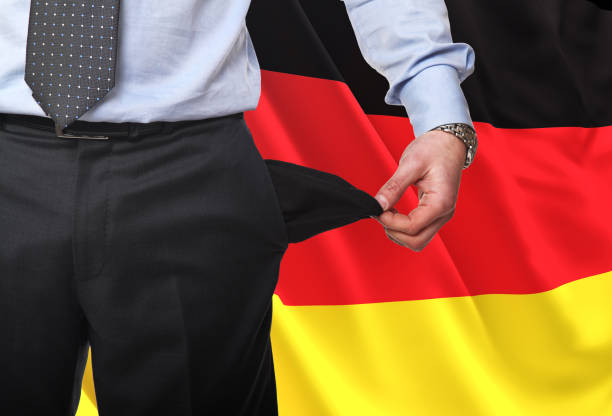 istock Midsection Of Businessman Showing Empty Pocket While Standing Against German Flag 1172751382