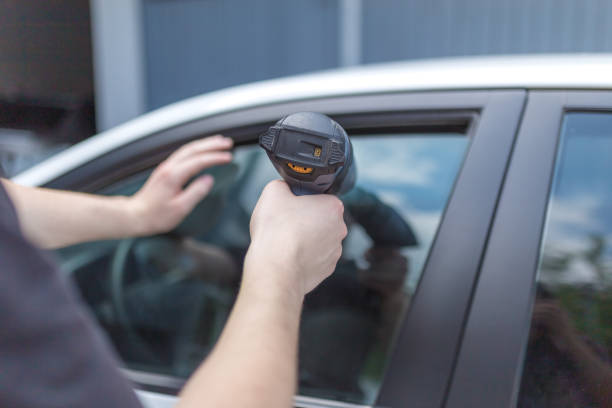 istock Worker removing car window film foil by using hot air gun. 1172753446