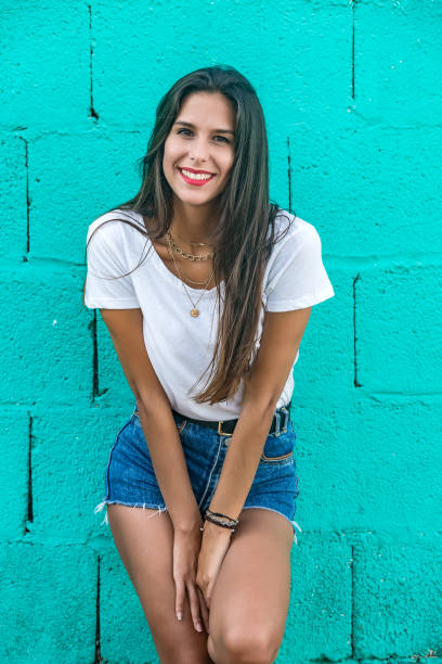 istock Beautiful stylish female standing by wall and smiling 1172756907