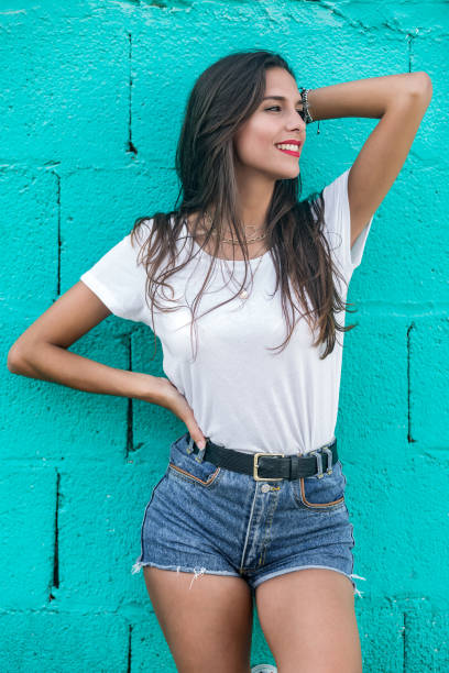 istock Beautiful brunette female standing by turquoise wall 1172756910