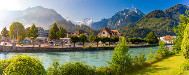 Old City of Interlaken, Switzerland Panoramic view of Old City with train station and Aare river. Interlaken, important tourist center in the Bernese Highlands, Switzerland. The Jungfrau is visible in the background jungfrau stock pictures, royalty-free photos & images