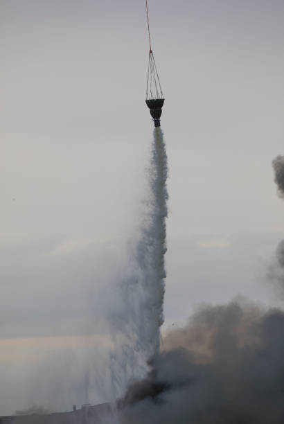 istock helicopter extinguishes a fire from a basket of water 1172758580