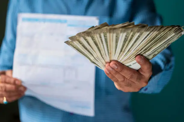 Photo of A Person Holding Bills and Money