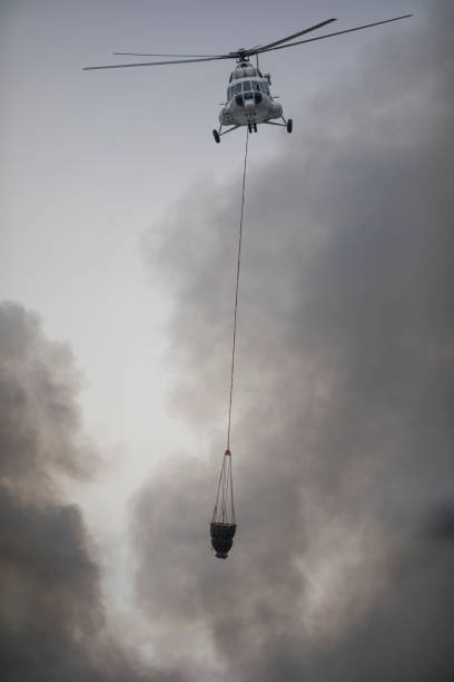 istock helicopter extinguishes a fire from a basket of water 1172759815