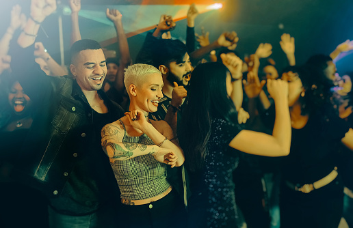 Cropped shot of a group of energetic friends people dancing at a party in a nightclub