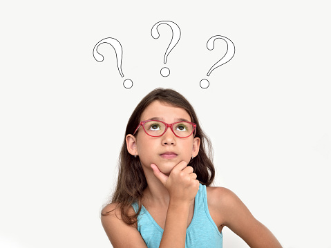 Thoughtful cute young girl wearing glasses with three question marks above her head