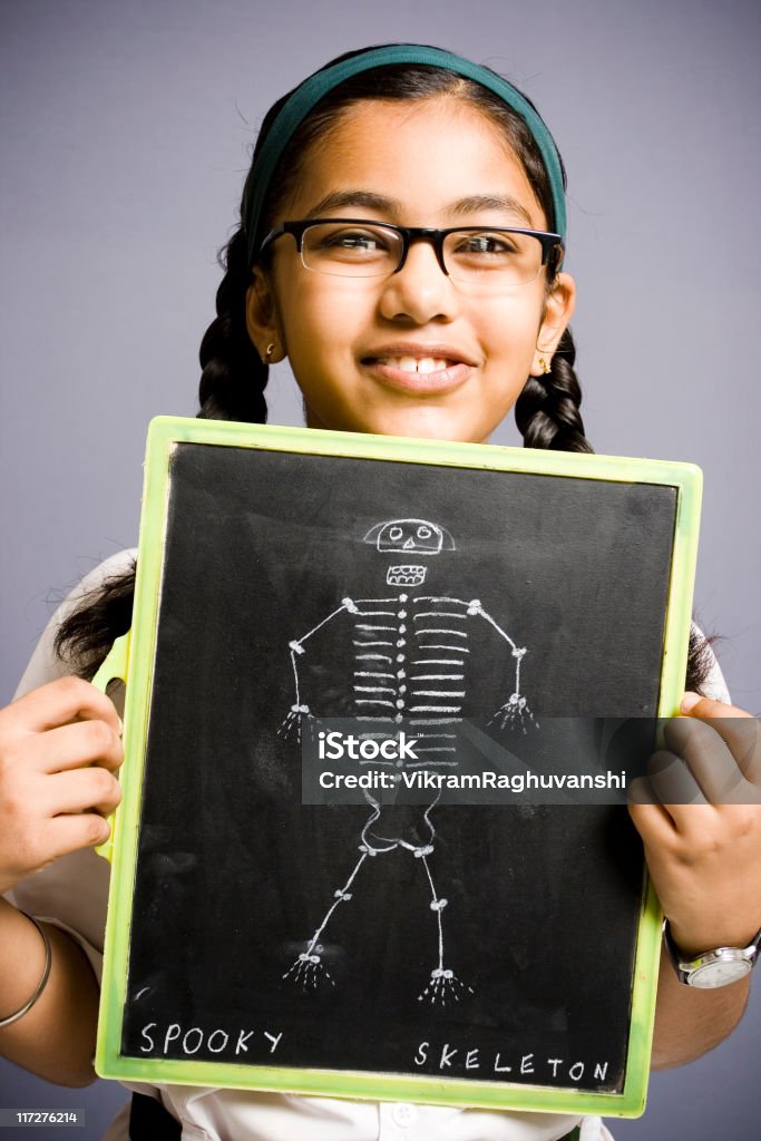 Alegre Indian school garota mostrando quadro-negro com desenho de skeleton - Foto de stock de Cultura Indiana royalty-free