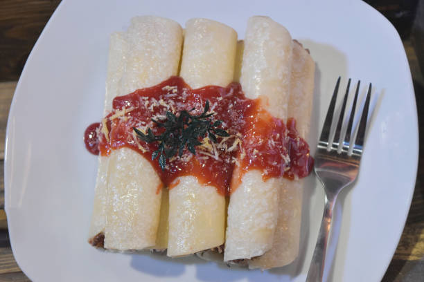 istock Roll pancakes with berries fruit sauce and fork on white plate. 1172763698