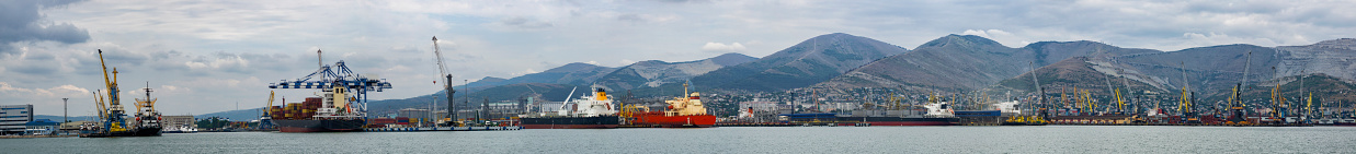 Sea trading port, at the foot of the mountains, panorama