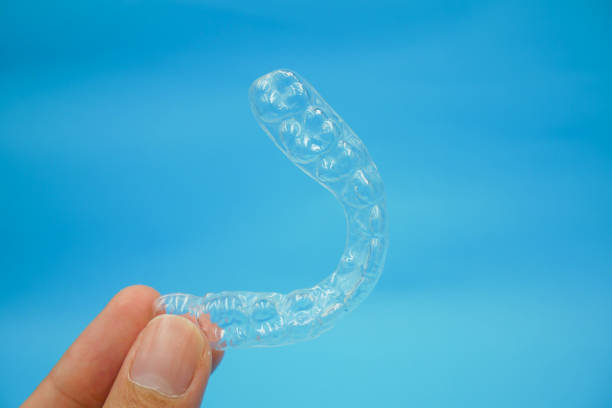 istock Beautiful clear plastic retainer teeth for orthodontics isolated on blue sky background 1172765387