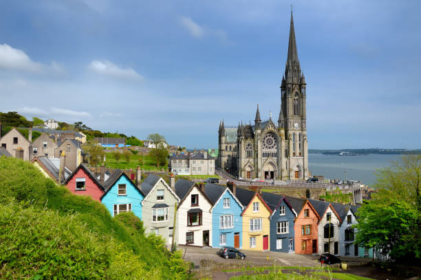 Colorful row houses with St. Colman's Cathedral in background in the port town of Cobh, County Cork, Ireland stock photo