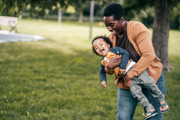 desarrollo emocional en los niños pequeños - family grass toddler african descent fotografías e imágenes de stock