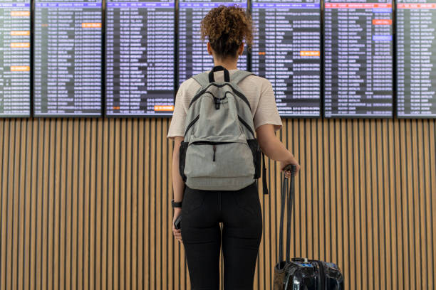 Young woman traveler looking at flight information