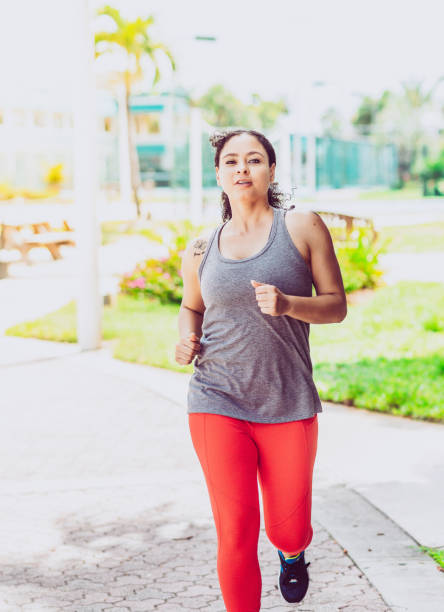 istock Attractive African american woman runs or jogs outdoors in workout gear 1172774529