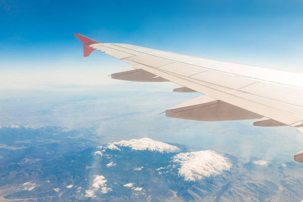 istock Aircraft wing on the clouds, flies on the mountains background 1172782230