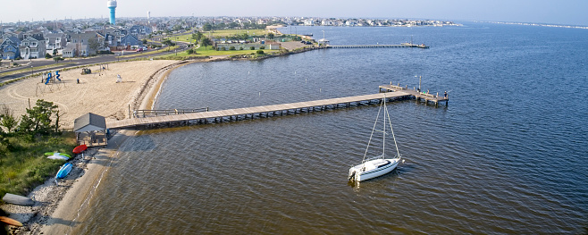 Drone point of view high up over water of fishing pier.