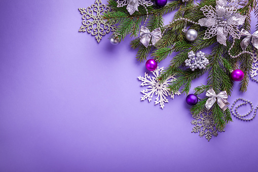 Purple Christmas and New Year background with decorated fir tree and toys. Copy space