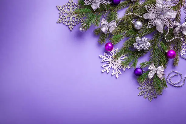Photo of Purple Christmas and New Year background with decorated fir tree and toys. Space