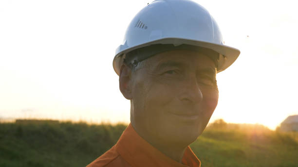 istock aged surveyor in orange jumpsuit types on modern smartphone 1172789819