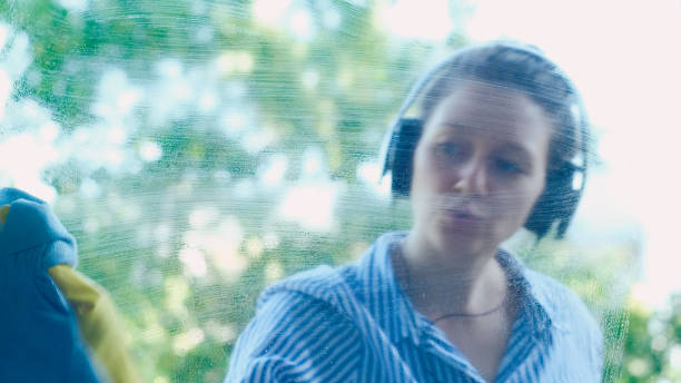 istock beautiful lady in modern black headphones sprays detergent 1172790384