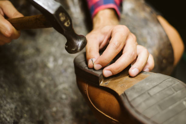 rzemieślnik naprawy lub podejmowania parę butów. - shoemaker zdjęcia i obrazy z banku zdjęć