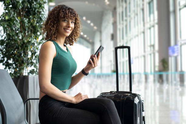 istock Woman using mobile phone in airport 1172792384