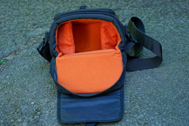empty black red camera bag lies on gray asphalt