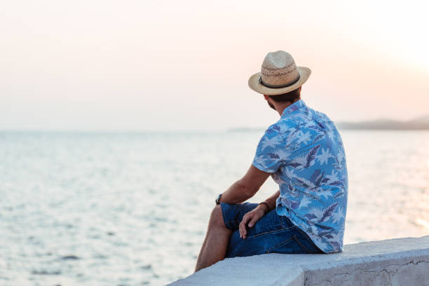 istock Young man enjoying sunset by the sea 1172794993