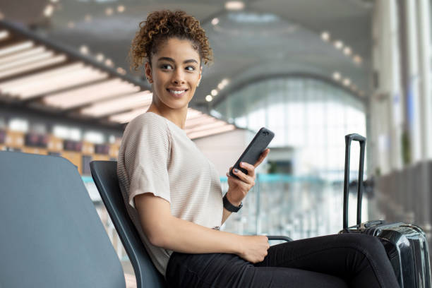 istock Woman using mobile phone in airport 1172798057