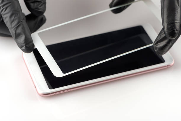 A man is holding a protective glass on a smartphone
