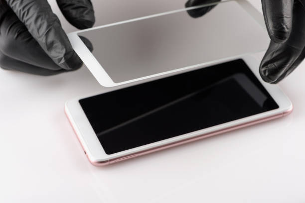 istock A man is installing a protective glass on the screen of a smartphone. 1172804793