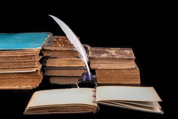 istock Writing pen, ink and old books on the table. Writer's desk ready for work. Dark background. 1172805092