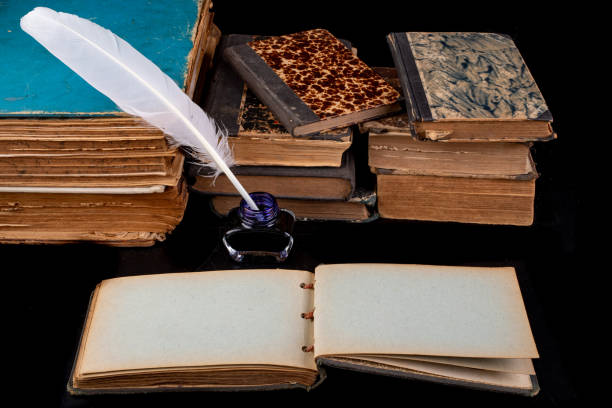 istock Writing pen, ink and old books on the table. Writer's desk ready for work. Dark background. 1172805097
