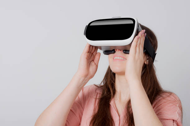istock Woman using VR device holding in both hands smiling and looking up 1172807099