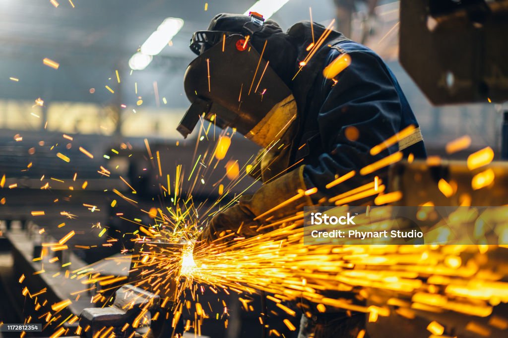 Metal worker using a grinder Manufacturing Stock Photo