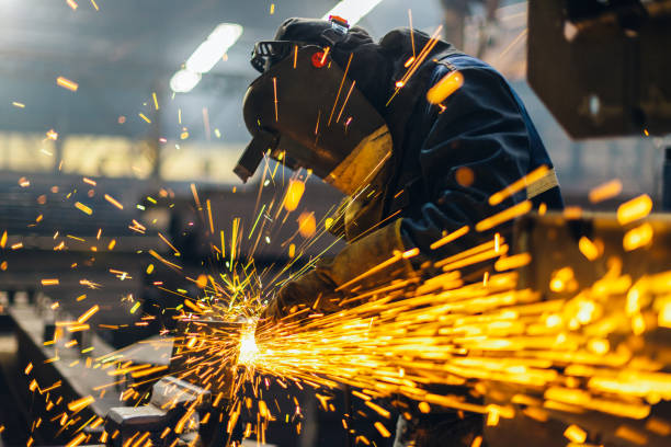 Metal worker using a grinder Metal worker using a grinder construction machinery photos stock pictures, royalty-free photos & images