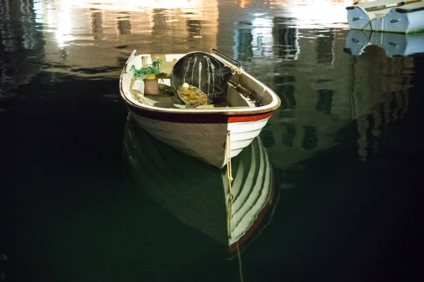 Blurry small wooden moored boat prow reflection in the shallow sea