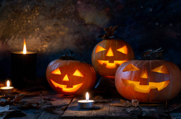 istock Three Halloween pumpkins head jack o lantern on wooden table background 1172814061