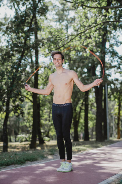 istock Young man exercising jumping rope in nature 1172819648