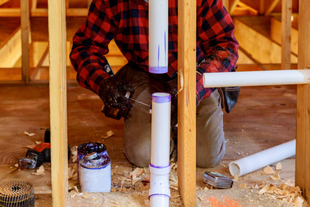 istock Plumber applying glue to PVC pipe under construction in new home 1172819785