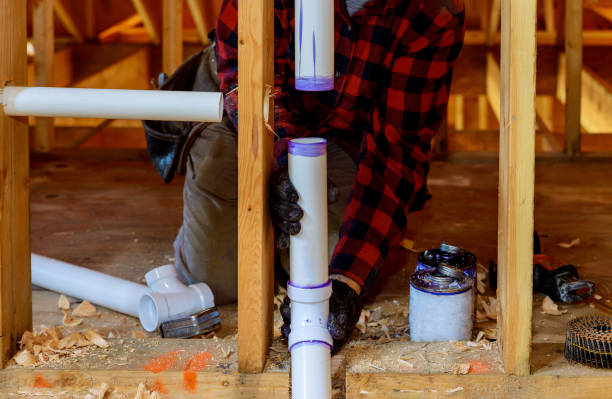 Plumber installing primer and glue PVC pipe at construction home Plumber installing primer and glue PVC pipe at construction new home pipe tube photos stock pictures, royalty-free photos & images