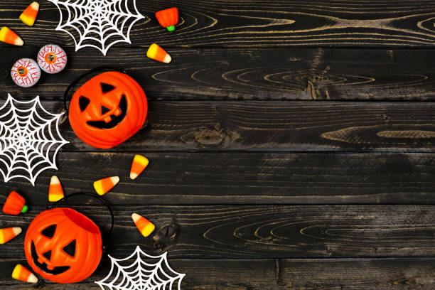 istock Halloween side border flat lay with candy and decor over a black wood background 1172822417