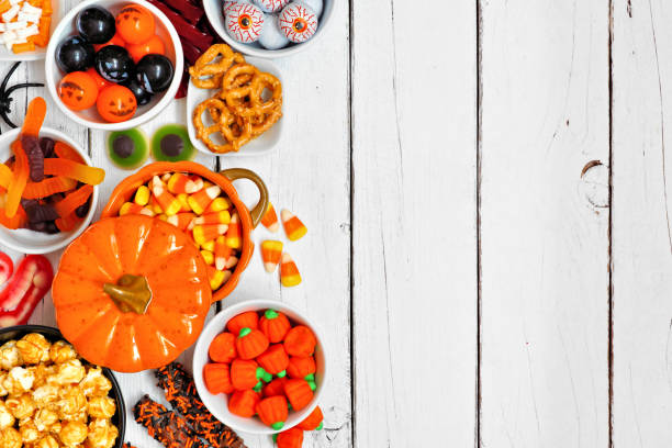 istock Halloween candy buffet table side border over a white wood background with copy space 1172822758